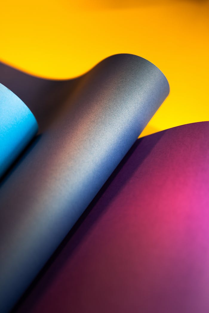 Close-up of colorful overlapping paper sheets creating a dynamic abstract pattern.